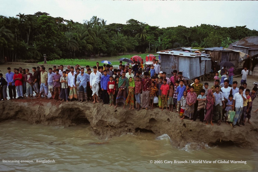 Bangladesh, villagers stand on road remnant one meter from tidewater of the delta. Sea level rise is increasing erosion.