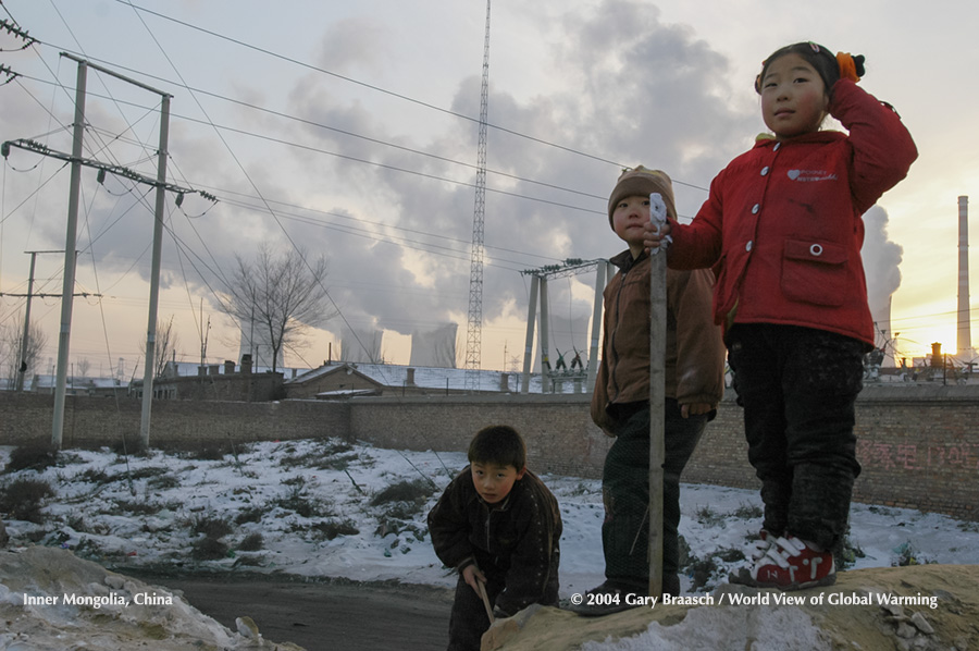 Three children play on pile of sand near the Dalate coal fired power plant, Ordos, Inner Mongolia, China. (See Coal)