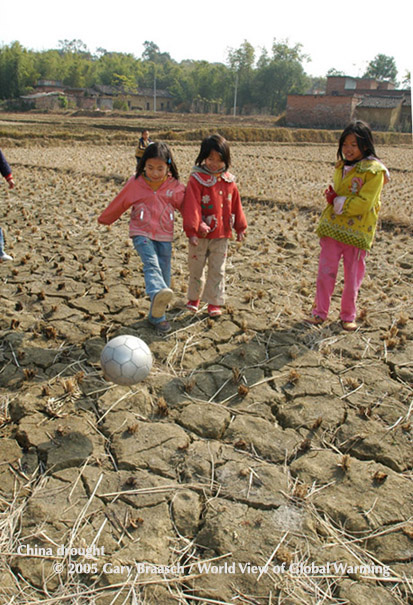 Kids play with soccer ball in rice fields that did not yield in severe drought, Fu Luo Village, northern Guangdong Prov., China 