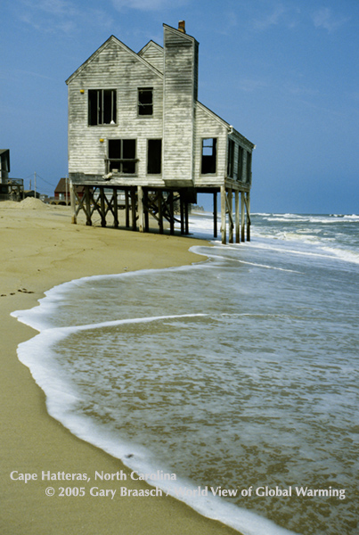 House on Cape Hatteras, Hatteras Island near Rodanthe, NC with dunes washed away and left  condemned, standing in surf.