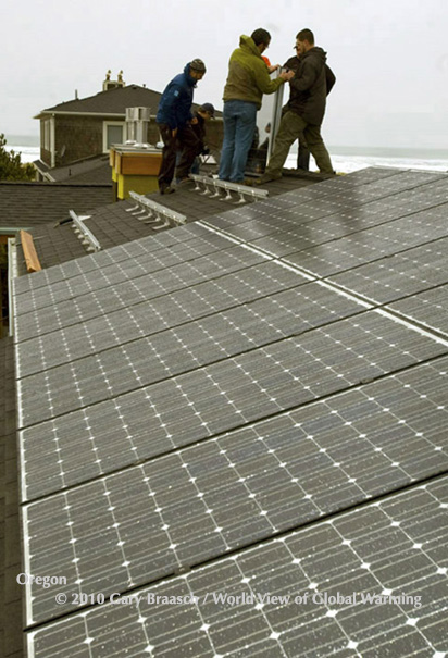 Crew from Tom Ayres Construction installs PV solar and solar hot water panels on the roof of home near the ocean in Manzanita Oregon.
