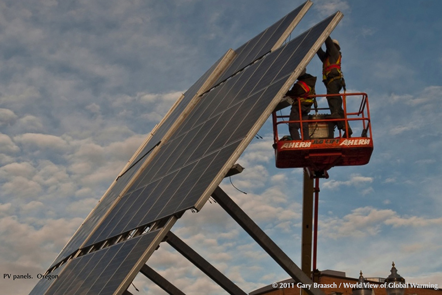 Large curving array of PV panels being installed at a MAX light rail station in Portland Oregon, to help power lights in area.